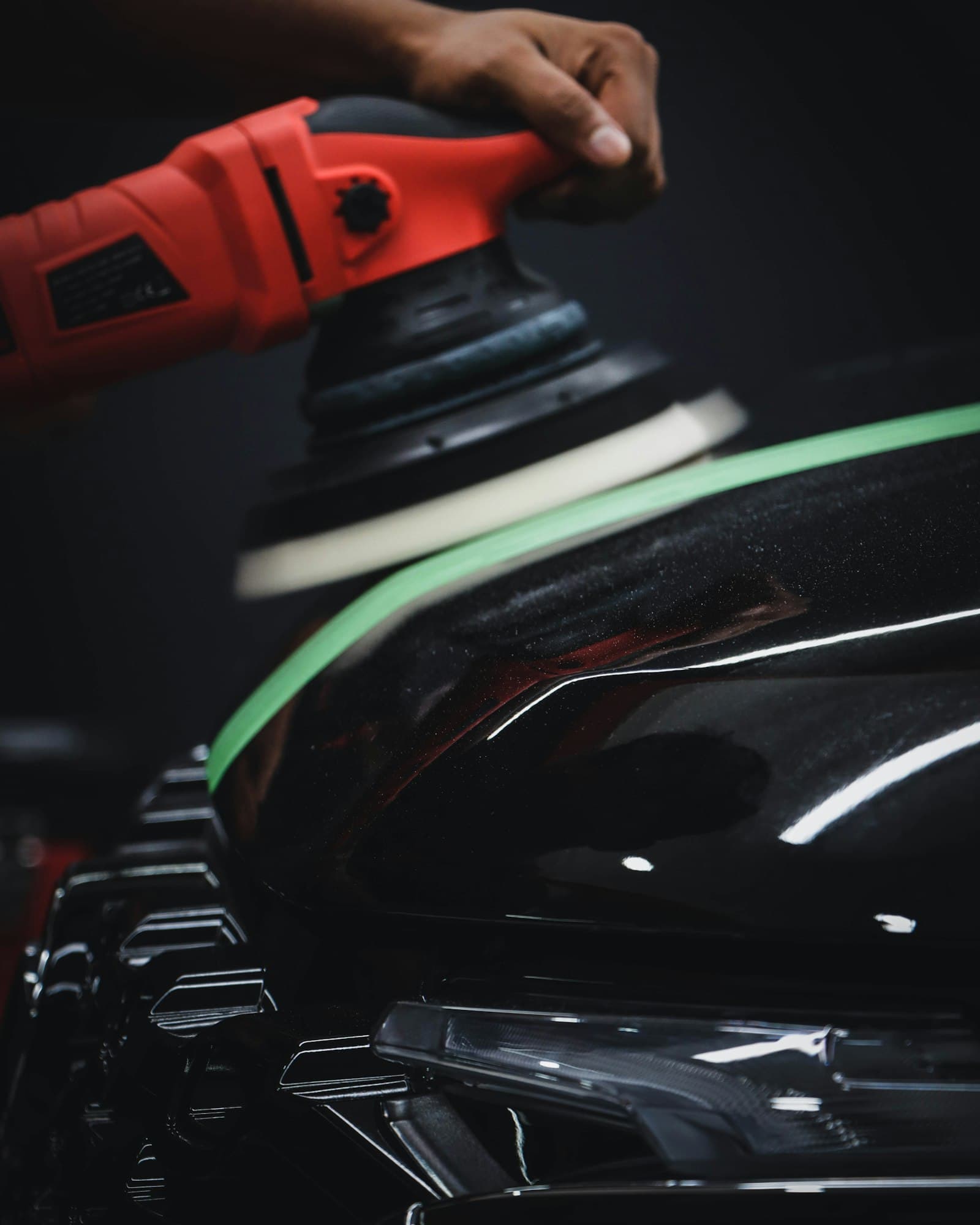 Machine polisher correcting glossy black paint